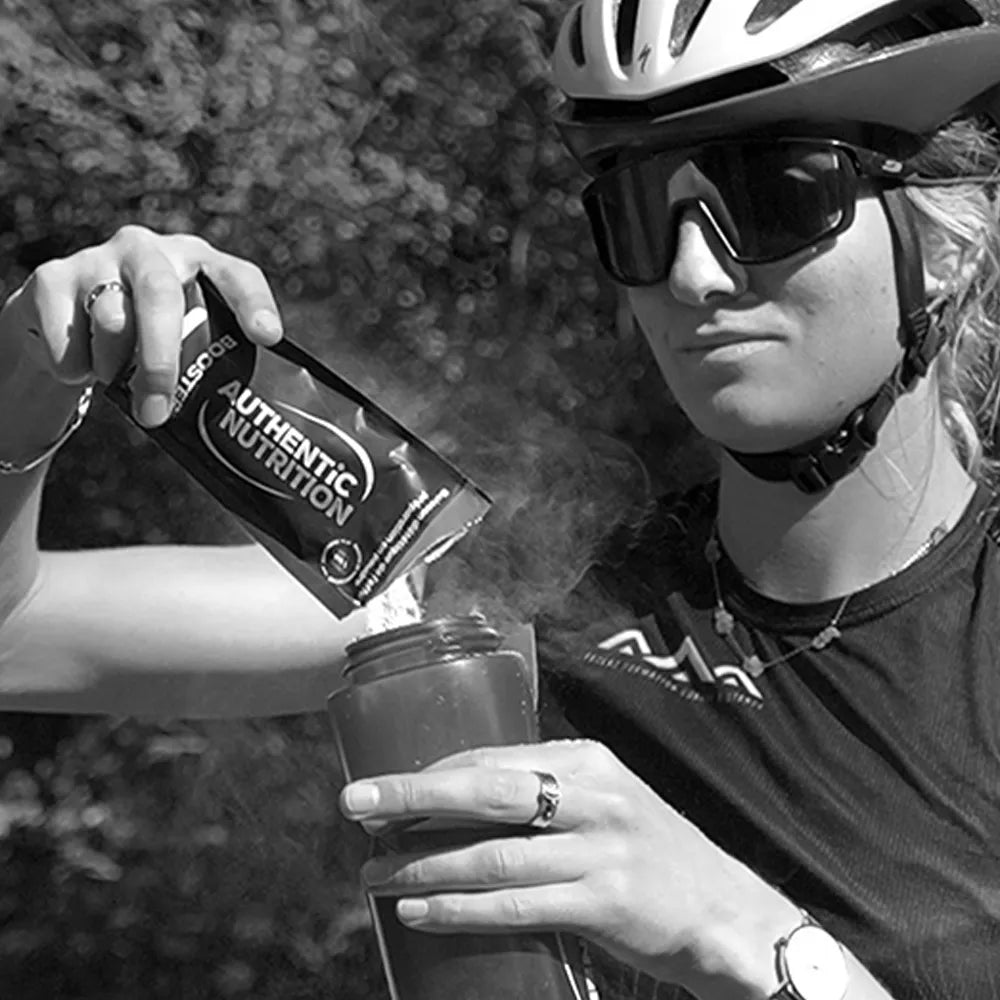 Cycliste préparant sa boisson avec un sachet Authentic Nutrition, hydratation sportive avant l'effort