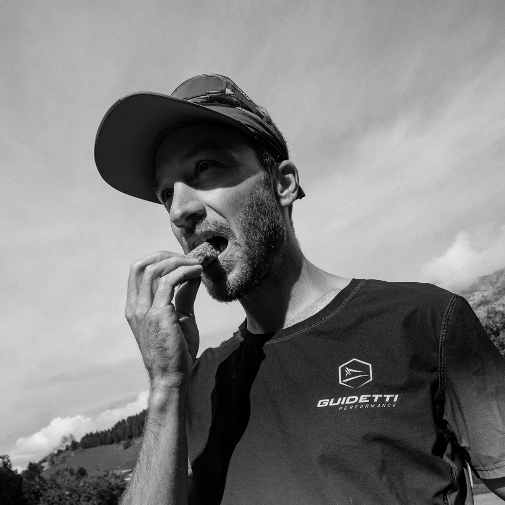 Traileur Guidetti en montagne s'alimentant pendant une sortie trail, équipement outdoor et randonnée