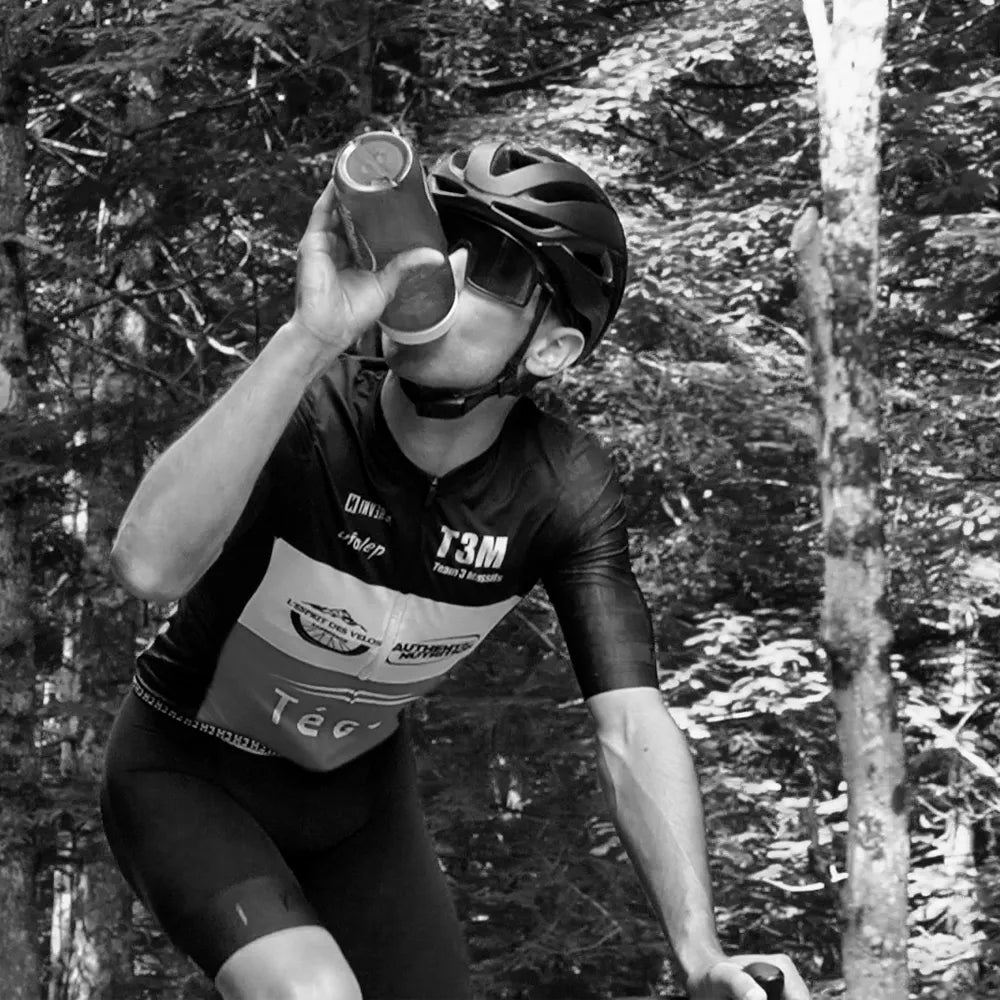 Cycliste s'hydratant à l'effort en pleine nature, hydratation sportive pendant un entraînement VTT